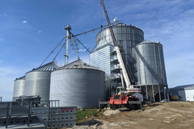 A crane helping place a grain handling equipment in Peoria IL, designed and fabricated by Morgan Millwright
